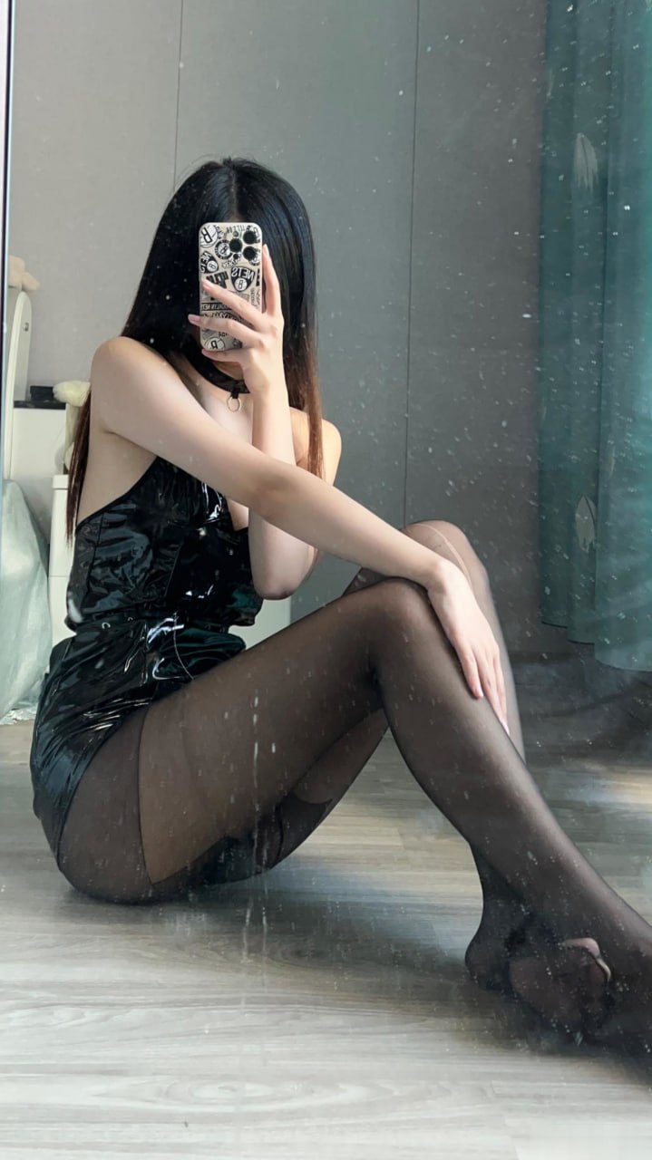 刘雅萌手持贴纸手机身着黑色亮面无袖装坐在地面 刘雅萌手持贴纸手机身着黑色亮面无袖装坐在地面