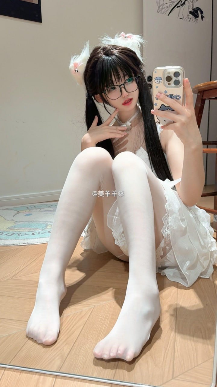 美羊羊桑戴白色猫耳和眼镜,穿浅色裙装坐在地面持手机拍镜面照 美羊羊桑戴白色猫耳和眼镜,穿浅色裙装坐在地面持手机拍镜面照