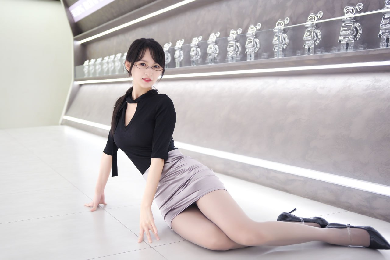 庭树沐年陈列架前黑色上衣和灰色裙装