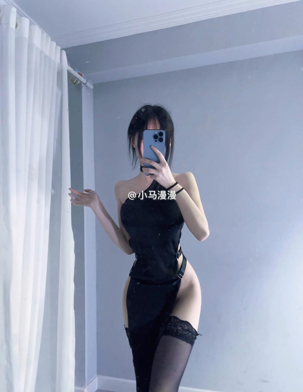 小马漫漫穿黑色挂颈造型站在镜前,手机遮住面部,左侧有白色窗帘 小马漫漫穿黑色挂颈造型站在镜前,手机遮住面部,左侧有白色窗帘