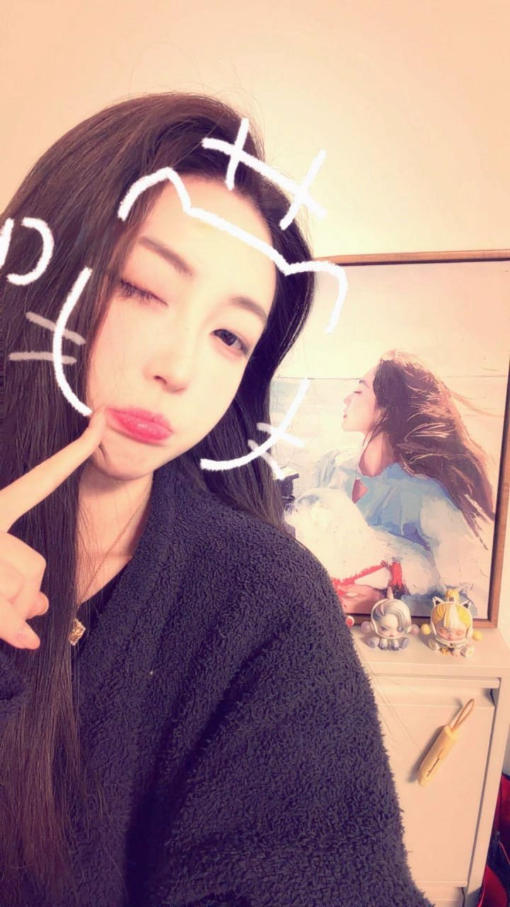 杨晚柠穿深色绒面外套拍摄带白色猫脸涂鸦的近景自拍