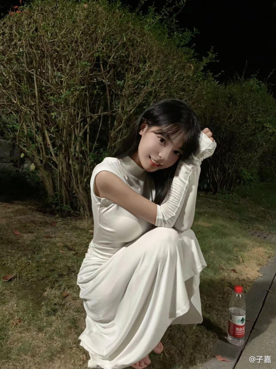子嘉穿白色长裙与长手套坐在夜间灌木前
