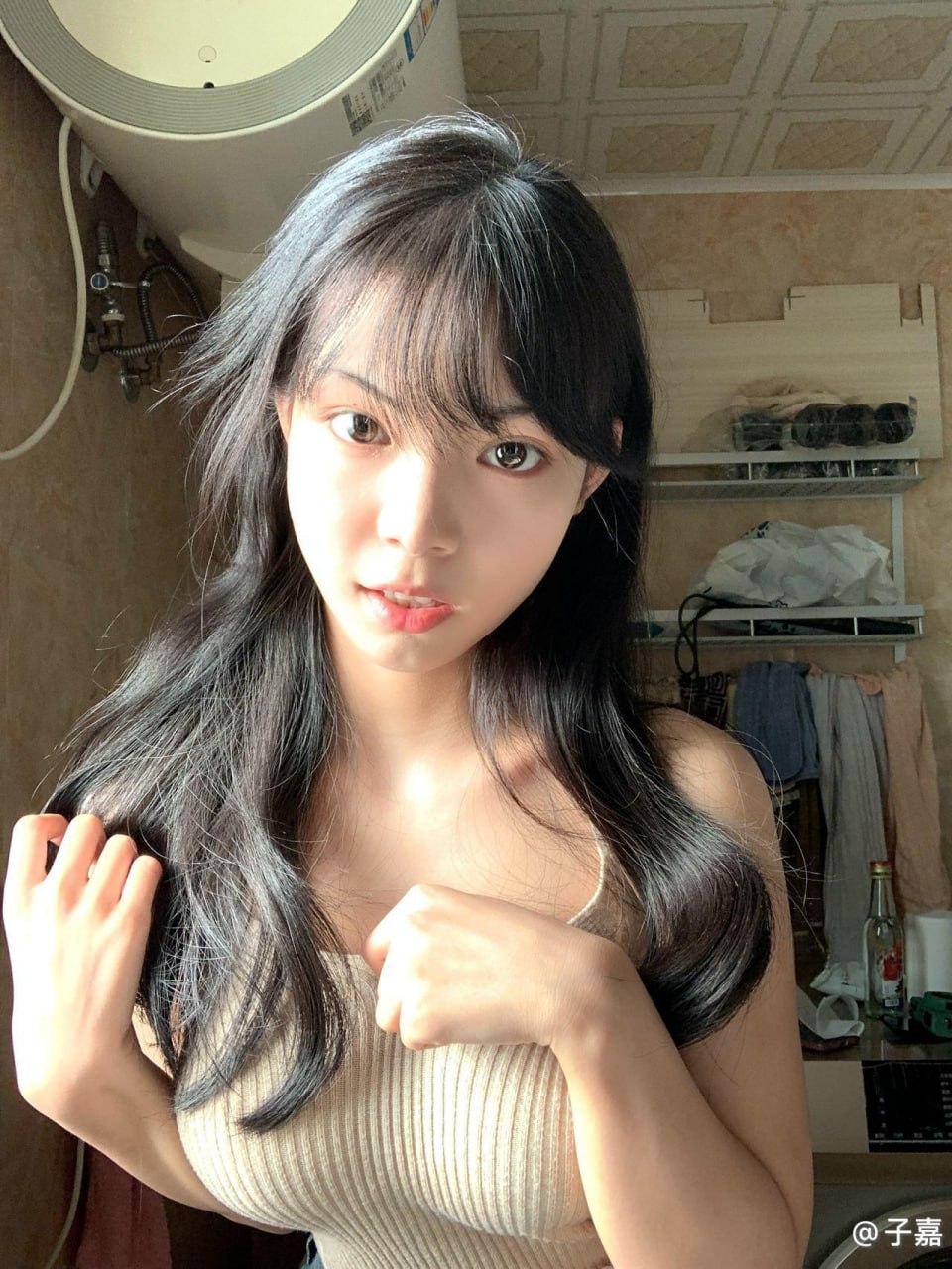 子嘉黑色长发配浅色罗纹上衣站在明亮背景前